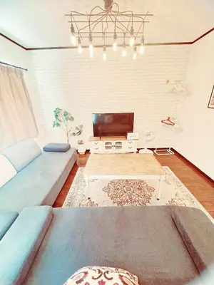 a living room with a blue couch and a tv at 4 min to JR Entire 3BR House w Garage Family Friendly Fast WiFi in Tokyo