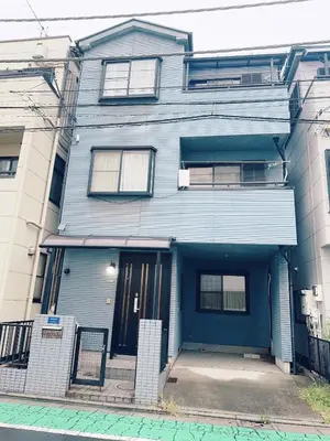 a blue house with a blue door on a street at 4 min to JR Entire 3BR House w Garage Family Friendly Fast WiFi in Tokyo