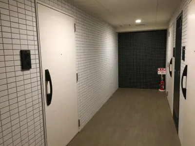 a hallway with white tile walls and a basketball hoop at SYFORME KEIKYU-KAMATA Room210 in Tokyo