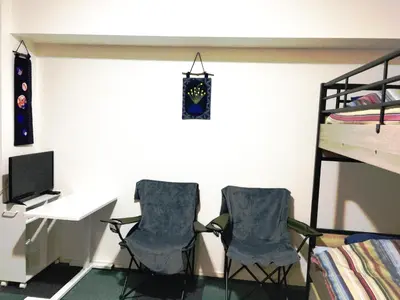 two chairs in a room with a desk and a bunk bed at SYFORME KEIKYU-KAMATA Room210 in Tokyo