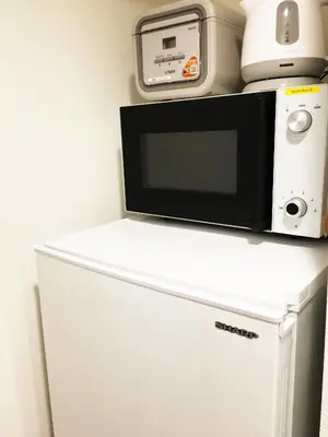 a microwave sitting on top of a refrigerator at SYFORME KEIKYU-KAMATA Room210 in Tokyo