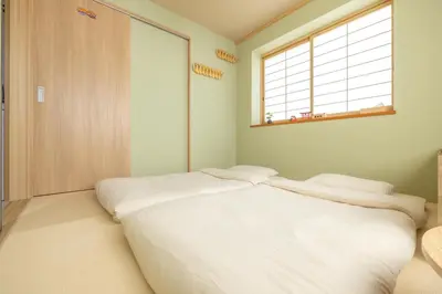 a bedroom with a large white bed with a window at Live the Anime Dream! Unique Themed Guest House for Families & Groups in Tokyo in Tokyo