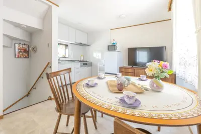 a dining room with a table and chairs and a kitchen at Live the Anime Dream! Unique Themed Guest House for Families & Groups in Tokyo in Tokyo