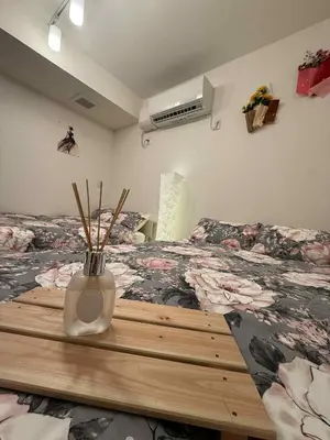 a bedroom with a bed and a vase on a table at The Rose Ueno in Tokyo