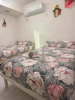 a bedroom with two beds with a floral bedspread at The Rose Ueno in Tokyo