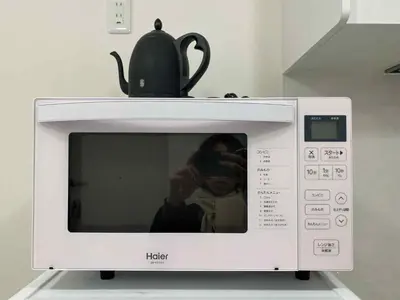 a person taking a picture of a microwave at The Rose Ueno in Tokyo