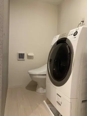 a washing machine in a bathroom with a toilet at The Rose Ueno in Tokyo