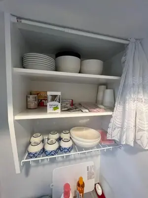 a refrigerator filled with plates and bowls on shelves at Sweet house 5 minutes walk from Shibuya station Dogenzaka apartment in Tokyo