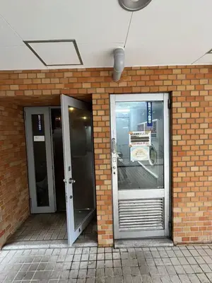 two glass doors in a brick wall next to a building at Sweet house 5 minutes walk from Shibuya station Dogenzaka apartment in Tokyo