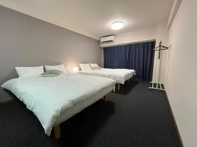 a hotel room with two beds and a window at Sweet house 5 minutes walk from Shibuya station Dogenzaka apartment in Tokyo