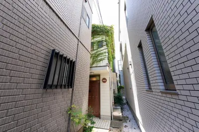 a small alley with a door in a building at Matsubara Station 2 minutes Shinjuku, Shibuya 15 minutes Pure Japanese style house where you can feel the seasons Maximum 6 people rent a house Quiet house in Tokyo