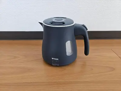 a black tea kettle sitting on a wooden floor at \u30db\u30c6\u30eb\u30ec\u30b9\u30dd\u30ef\u30fc\u30eb402 in Tokyo