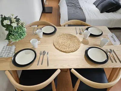 a wooden table with black and white plates and silverware at \u30db\u30c6\u30eb\u30ec\u30b9\u30dd\u30ef\u30fc\u30eb402 in Tokyo