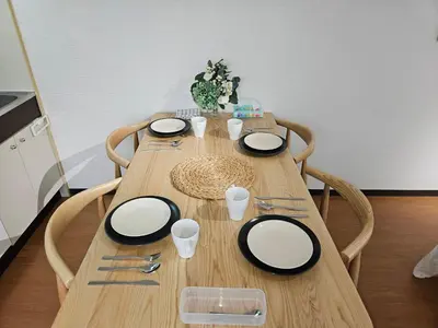 a wooden table with black and white plates and silverware at \u30db\u30c6\u30eb\u30ec\u30b9\u30dd\u30ef\u30fc\u30eb402 in Tokyo