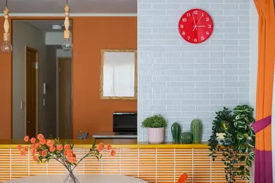 a clock on a wall above a table with plants at Skytree View Rooftop Villa Asakusa SVRVA in Tokyo