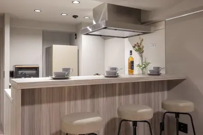 a kitchen with a bar with stools and a bottle of wine at CLASS Shinagawa in Tokyo