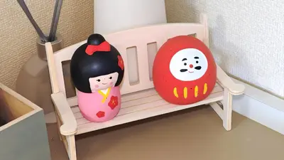 two toy dolls sitting on a chair in a room at SkyTree-401 in Tokyo