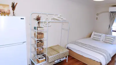 a bedroom with a white bed and a white refrigerator at SkyTree-401 in Tokyo