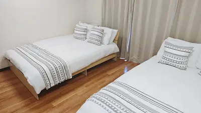 two beds in a room with white and black pillows at SkyTree-401 in Tokyo