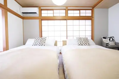 two beds in a room with a window at Yumenoya Yoyogi in Tokyo
