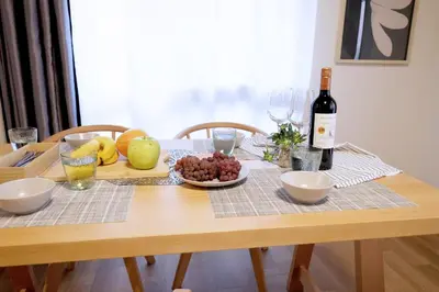 a wooden table with a bottle of wine and fruit at Yumenoya Yoyogi in Tokyo