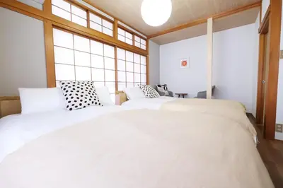 two beds in a room with large windows at Yumenoya Yoyogi in Tokyo