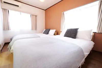 two beds in a room with two windows at Yumenoya Yoyogi in Tokyo