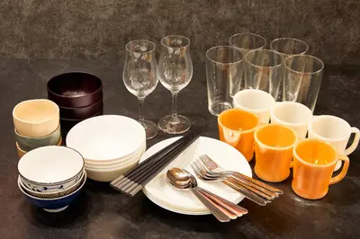 a table with plates and wine glasses and utensils at \u3068\u307e\u308a\u30fc\u3068Stay\u65b0\u5bbf Tomareat Stay Shinjuku in Tokyo