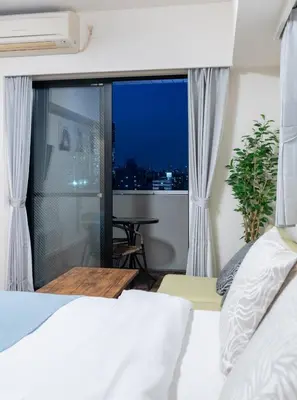 a bedroom with a bed and a view of the city at \u30ec\u30b8\u30c7\u30f3\u30b7\u30e3\u30eb\u30b9\u30c6\u30fc\u30b81107 in Tokyo