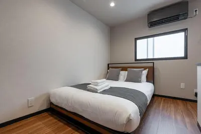 a bedroom with a bed with white sheets and a window at Newly Opened \u6c60\u888b\u30c6\u30e9\u30b9\u30cf\u30a6\u30b9A in Tokyo