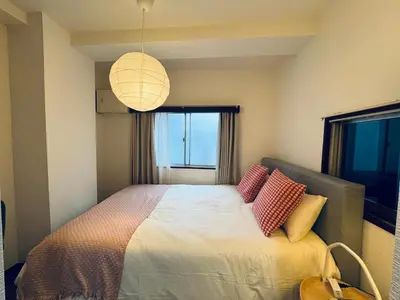 a bedroom with a bed with red and yellow pillows at Shinjuku JX-101 SJ0283 in Tokyo