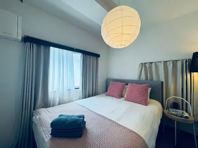 a bedroom with a bed with pink pillows and a large window at Shinjuku JX-101 SJ0283 in Tokyo