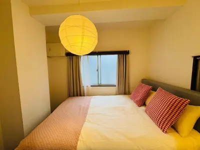 a bedroom with a bed with two red and yellow pillows at Shinjuku JX-101 SJ0283 in Tokyo
