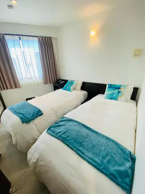 a hotel room with two beds and a window at Omori Happy Smile Hotel in Tokyo