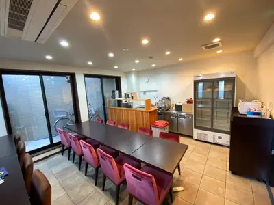 a dining room with a table and pink chairs at Omori Happy Smile Hotel in Tokyo