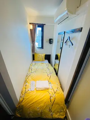 a small bedroom with a yellow bed in it at Omori Happy Smile Hotel in Tokyo