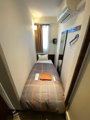 a small bedroom with a bed in a small room at Omori Happy Smile Hotel in Tokyo