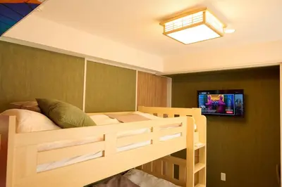 a bedroom with a bunk bed with a tv on a wall at 1min to Station 25min Disney Resort Direct Narita 1Transfer Shibuya CVS 30s Girls Trip Family Stay \u99c5\u5f92\u6b691\u5206 \u30c7\u30a3\u30ba\u30cb\u30fc\u30ea\u30be\u30fc\u30c825\u5206 \u6210\u7530\u7a7a\u6e2f\u76f4\u901a \u6e0b\u8c371\u56de\u4e57\u63db \u30b3\u30f3\u30d3\u30cb30\u79d2 \u5973\u5b50\u65c5 \u5bb6\u65cf\u65c5\u884c in Tokyo