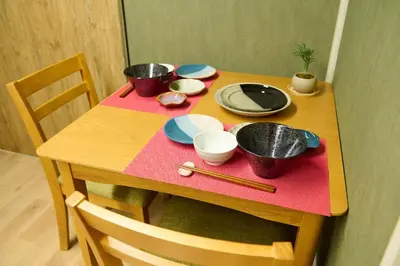 a wooden table with bowls and plates on a pink napkin at 1min to Station 25min Disney Resort Direct Narita 1Transfer Shibuya CVS 30s Girls Trip Family Stay \u99c5\u5f92\u6b691\u5206 \u30c7\u30a3\u30ba\u30cb\u30fc\u30ea\u30be\u30fc\u30c825\u5206 \u6210\u7530\u7a7a\u6e2f\u76f4\u901a \u6e0b\u8c371\u56de\u4e57\u63db \u30b3\u30f3\u30d3\u30cb30\u79d2 \u5973\u5b50\u65c5 \u5bb6\u65cf\u65c5\u884c in Tokyo
