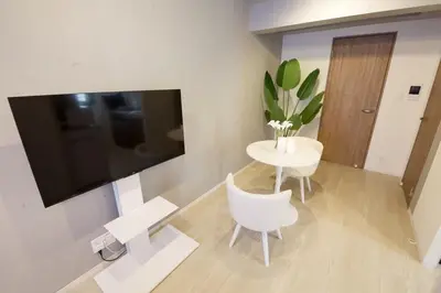 a living room with a table and a white chair at Heureux Shiinamachi 201 in Tokyo