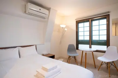 a bedroom with a bed and a desk and a window at R Inn \u65b0\u4e95\u85ac\u5e2b\u524d in Tokyo