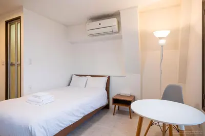 a bedroom with a bed and a table and a chair at R Inn \u65b0\u4e95\u85ac\u5e2b\u524d in Tokyo