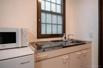 a kitchen with a microwave and a sink at R Inn \u65b0\u4e95\u85ac\u5e2b\u524d in Tokyo