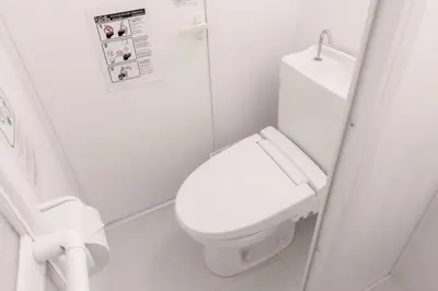 a white bathroom with a toilet and a sink at R Inn \u65b0\u4e95\u85ac\u5e2b\u524d in Tokyo