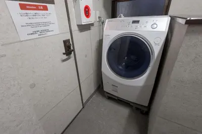 a washer and dryer in a small room at R Inn \u65b0\u4e95\u85ac\u5e2b\u524d in Tokyo