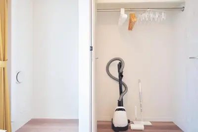 a room with a white wall and a black and white vacuum at monthly AQUA RESIDENCE Sangenjaya in Tokyo