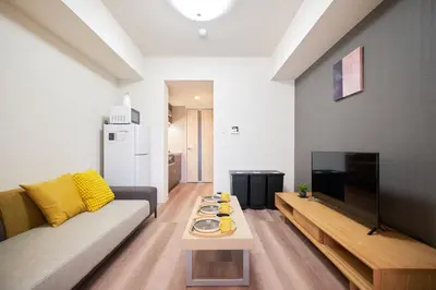 a living room with a couch and a tv at monthly AQUA RESIDENCE Sangenjaya in Tokyo