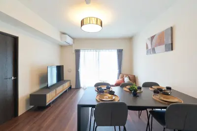 a living room with a table and chairs and a television at monthly AQUA RESIDENCE Sangenjaya in Tokyo