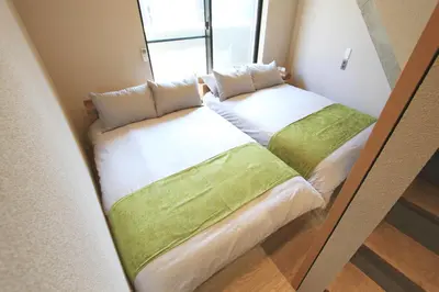 two beds in a small room with a window at \u62b9\u8336\u5eb5\u4e09\u8336\u6771\u4eac Matcha-An Sancha Tokyo #202 in Tokyo