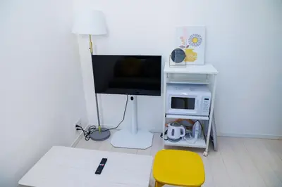 a living room with a tv and a yellow chair at Cruise Inn Kitasenju Station Front1 in Tokyo